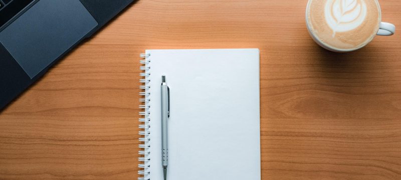 资深香港彩玩家在桌前整理开奖数据记录表，笔记本上密密麻麻的号码统计，旁边放着计算器和咖啡，专注认真的研究氛围
